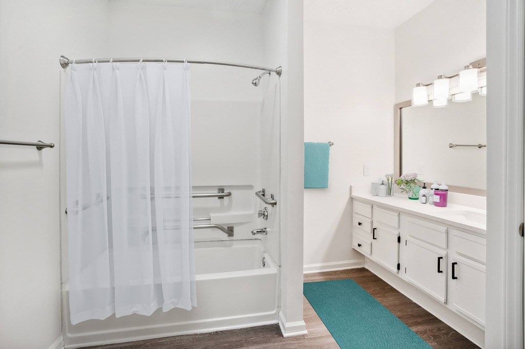 A white bathroom with a white tub and shower curtain.