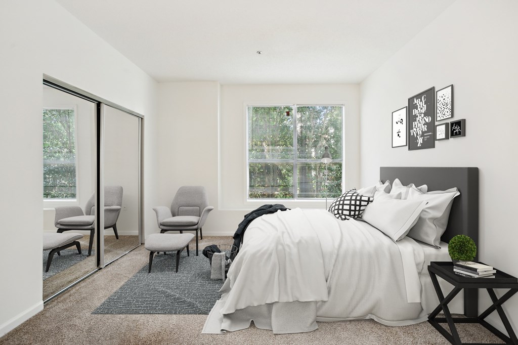A bedroom with a large bed and a window with a view of trees.