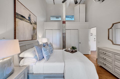 A bedroom with a large bed and a painting on the wall.