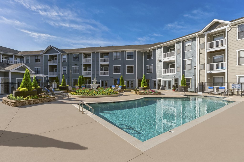 an apartment building with a swimming pool in front of it
