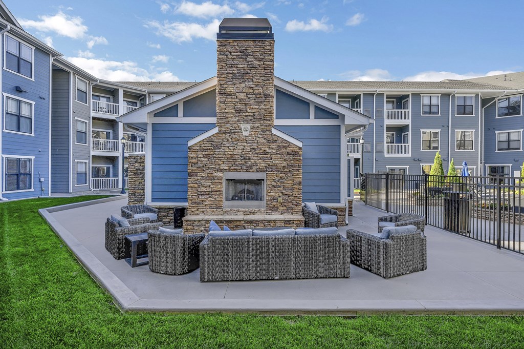 a courtyard with a stone fireplace and a table and chairs