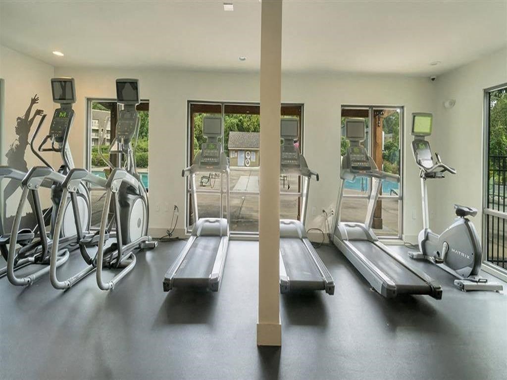 the gym is equipped with cardio equipment and views of the pool
