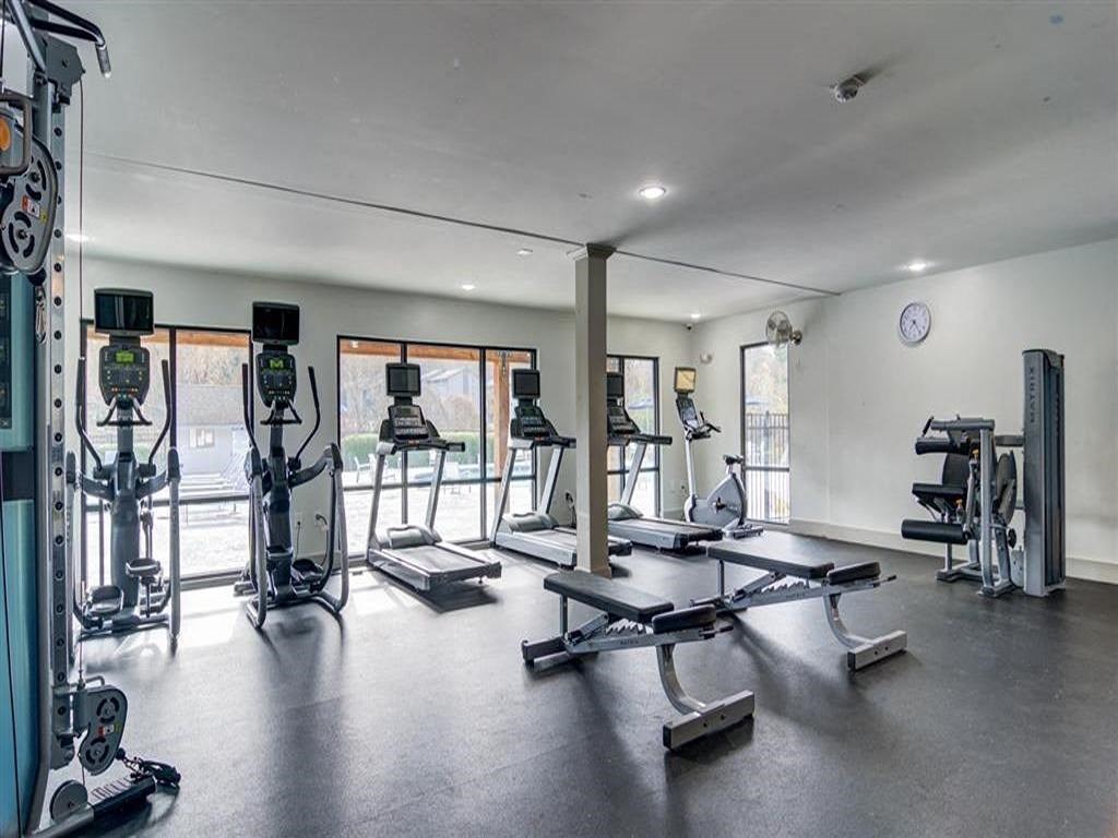 a gym with weights and other equipment and windows