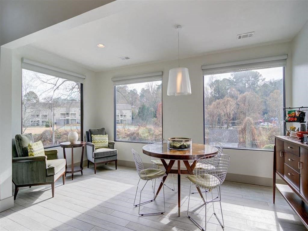 a living room with a table and chairs and a large window