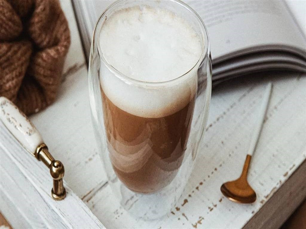 a cup of coffee and a book on a table