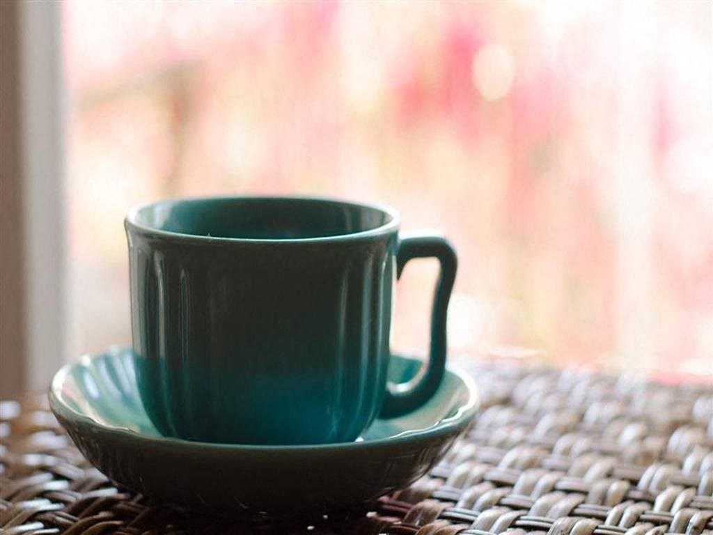 a green mug and a plate on a table
