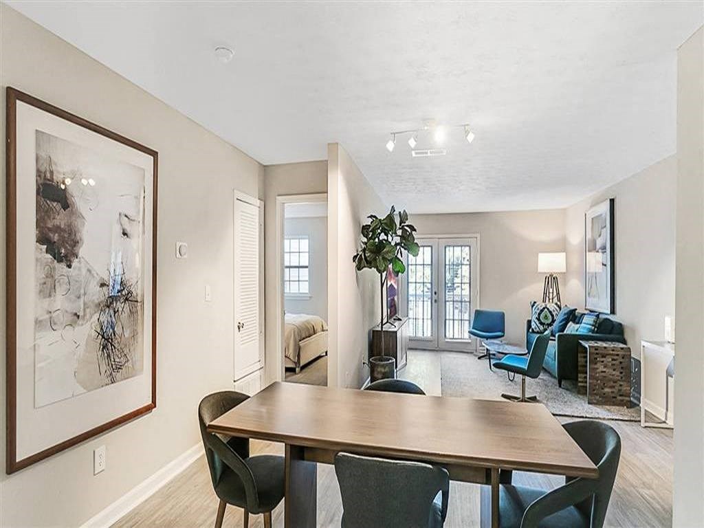 a living room and dining room with a table and chairs