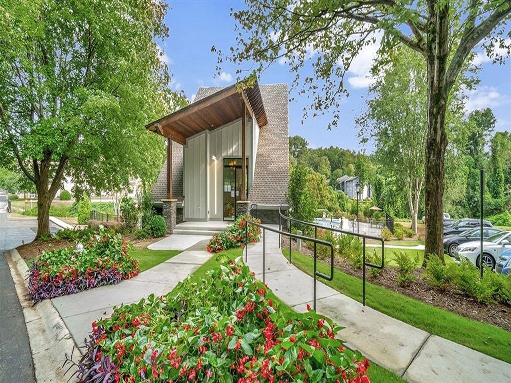 the front of a house with a sidewalk and trees
