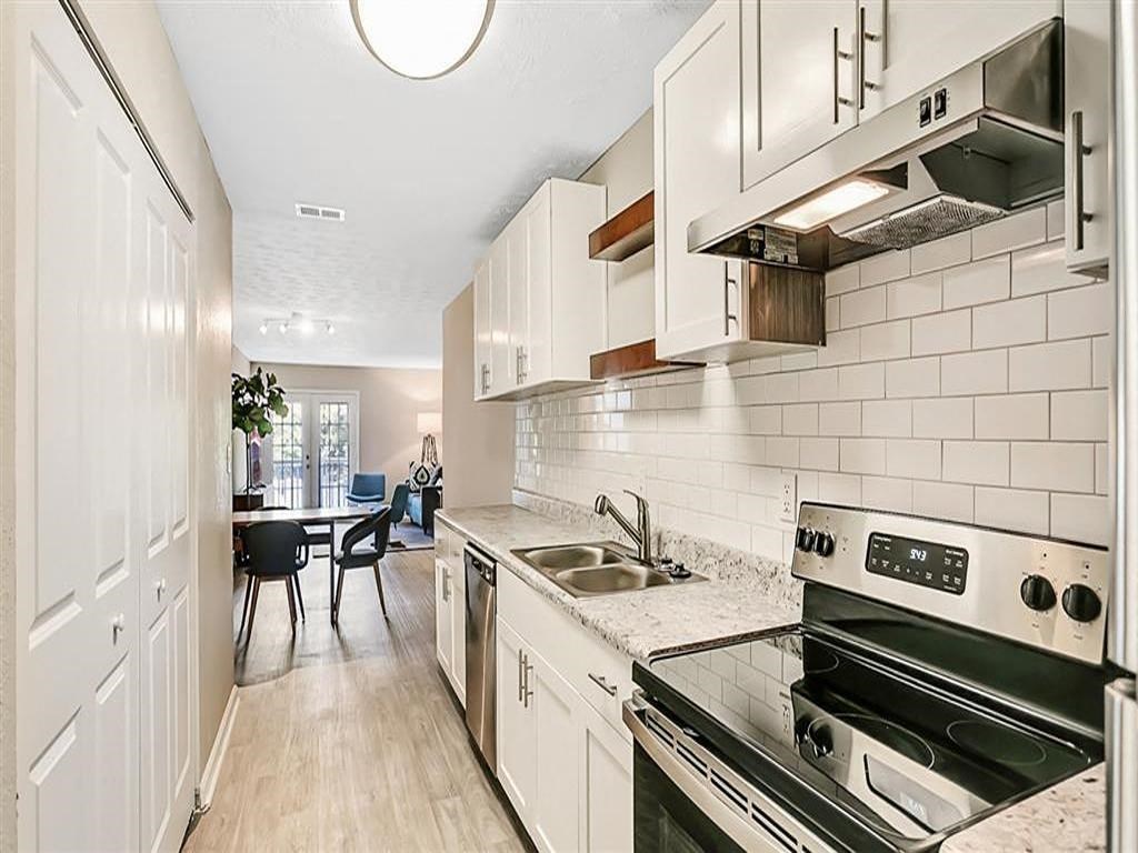a white kitchen with a stove and a sink
