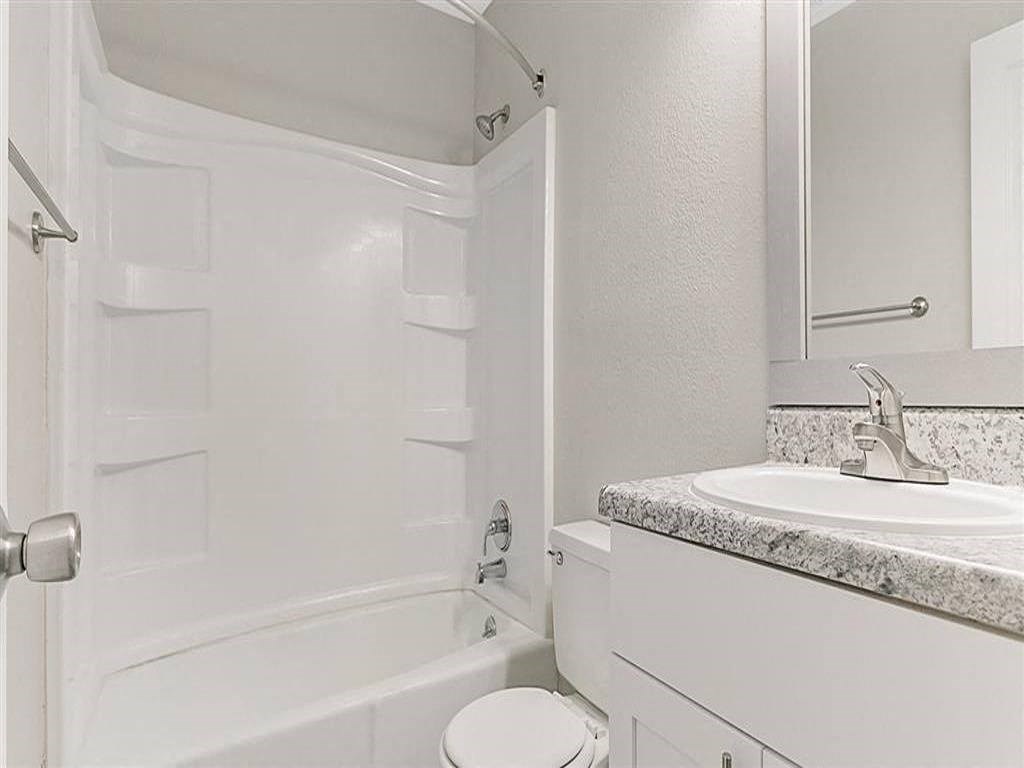 a white bathroom with a sink and a toilet