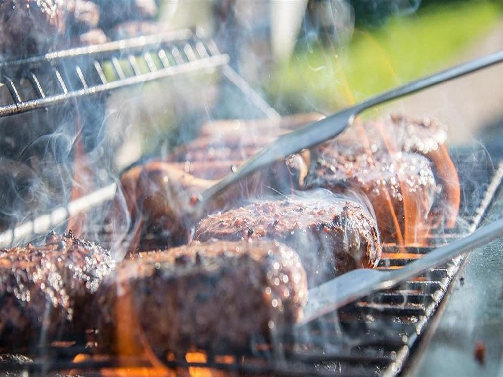 a grill filled with meat cooking on top of it