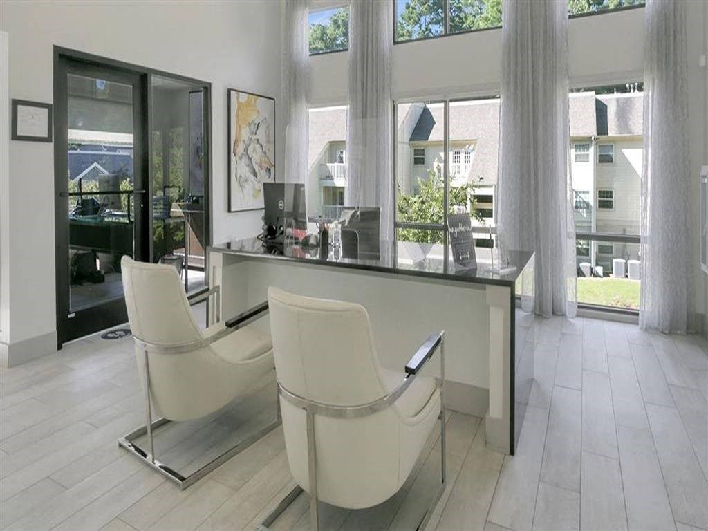 a white office with two white chairs and a desk