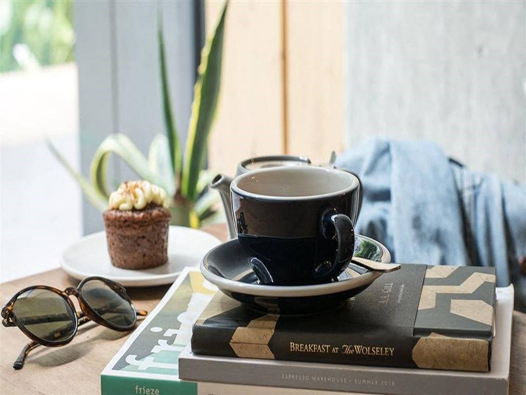 a cup of coffee sitting on a book on a table