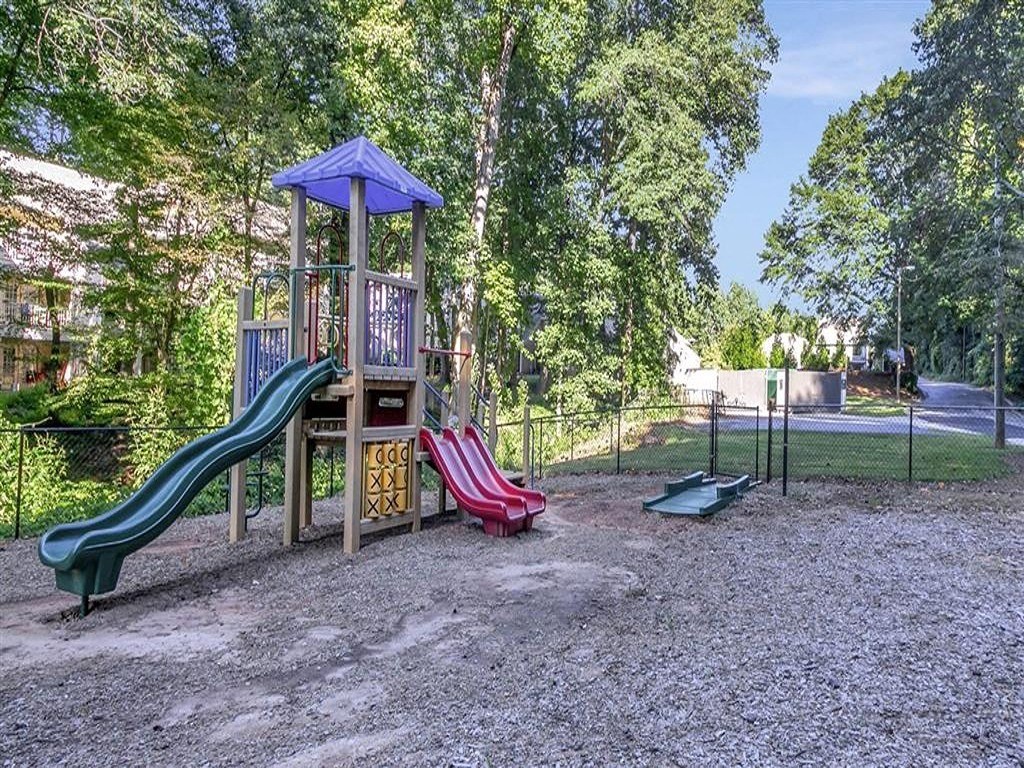a playground with a swing set and slides in a park