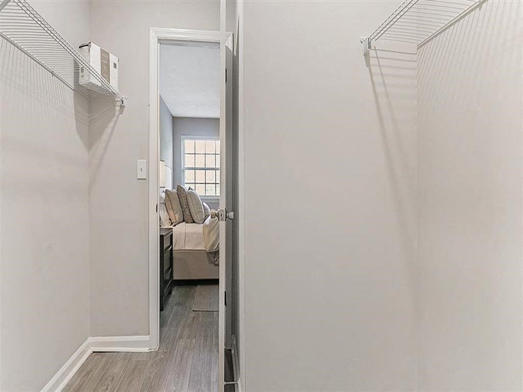 a hallway with a door to a bedroom and a closet