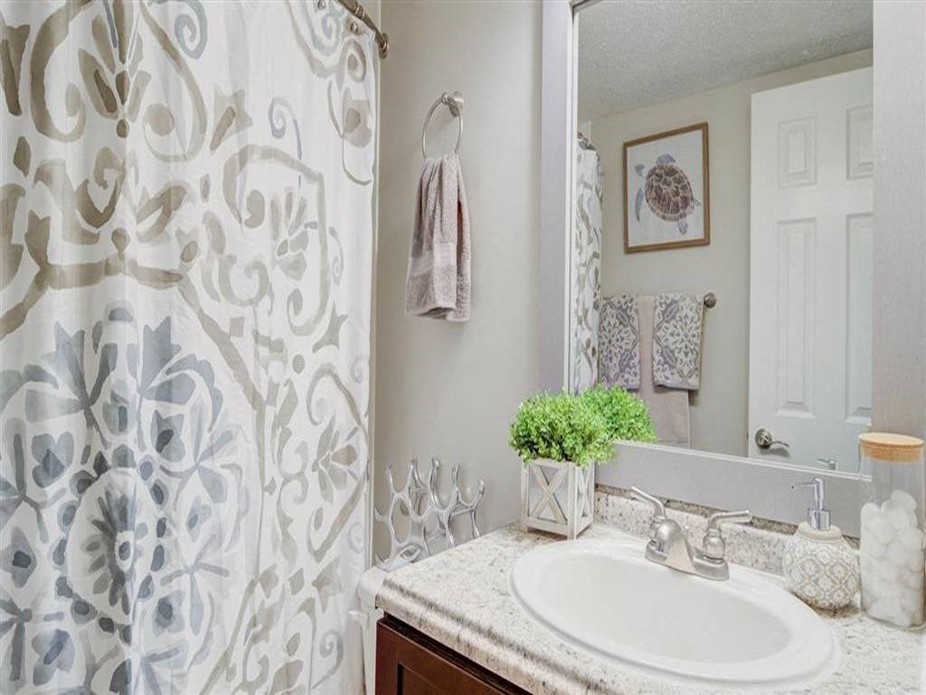 a bathroom with a shower and a sink and a mirror