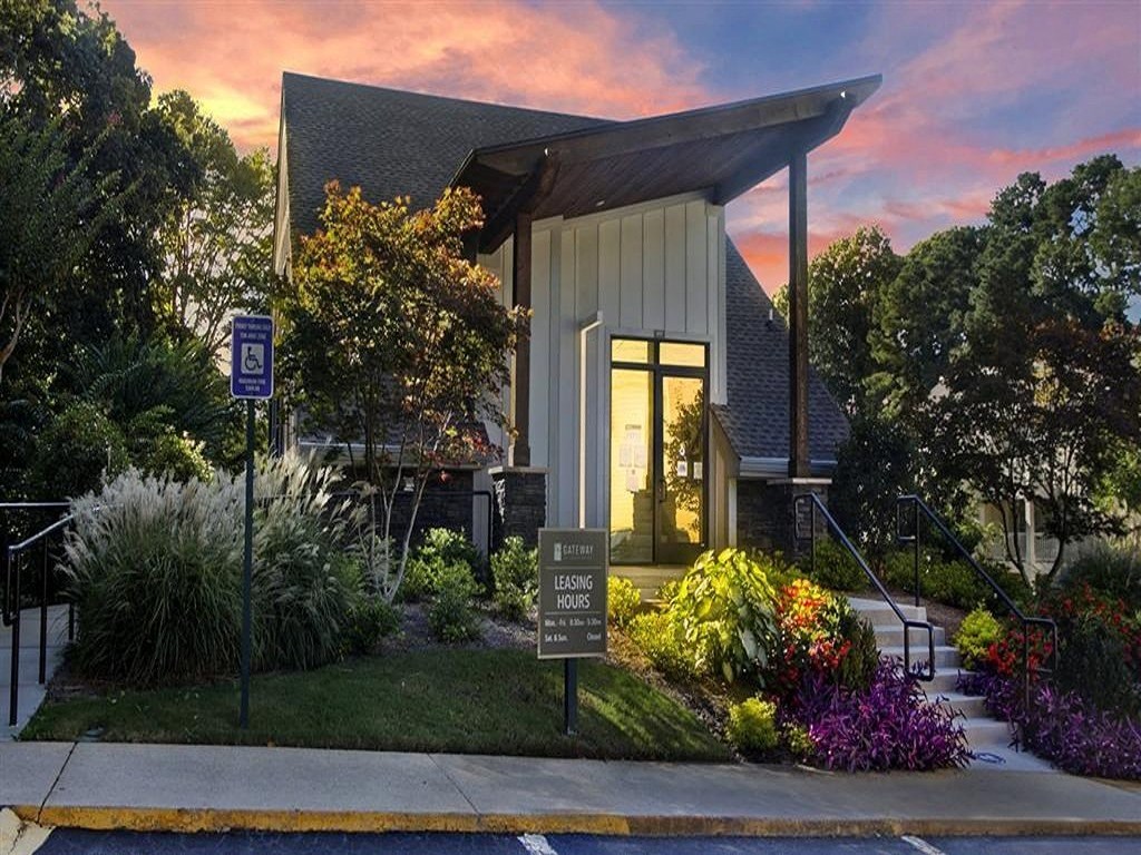 the front of a church with a sign in front of the front yard with flowers