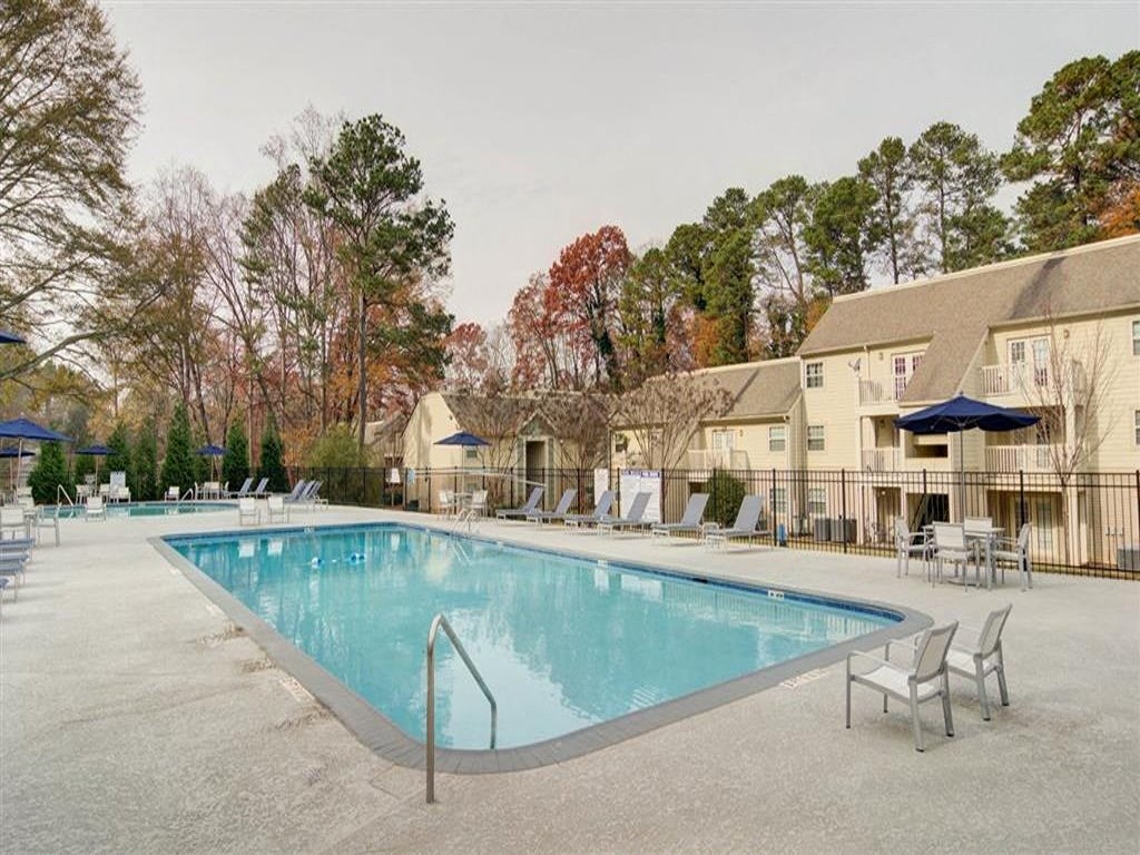 a resort style pool with chairs and umbrellas