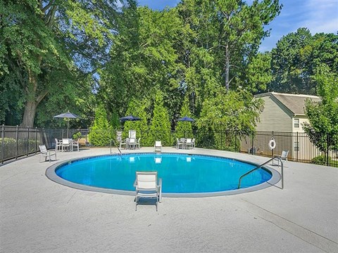 a blue swimming pool with chairs around it