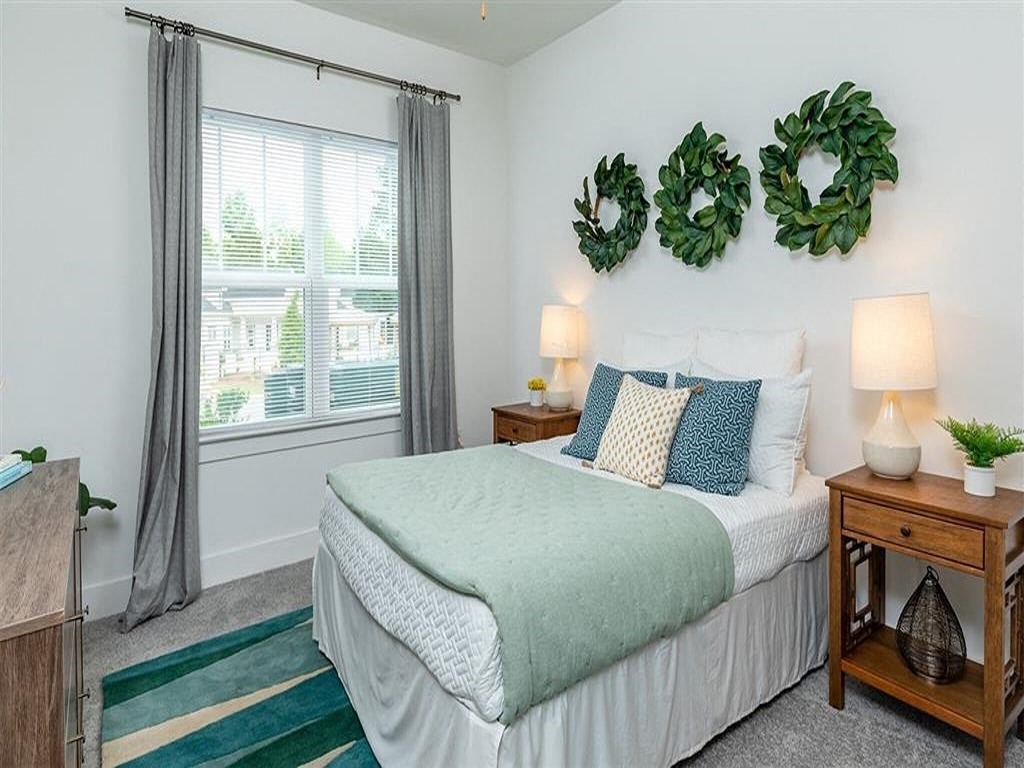 a bedroom with a bed and plants on the wall