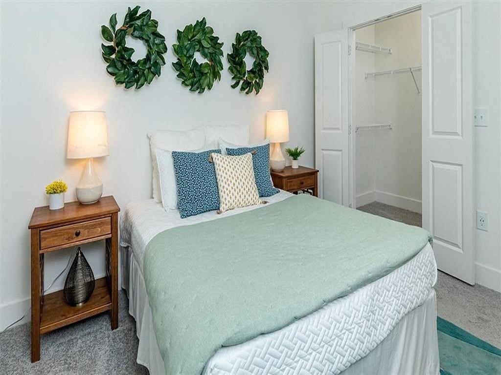 a bedroom with a bed and plants on the wall