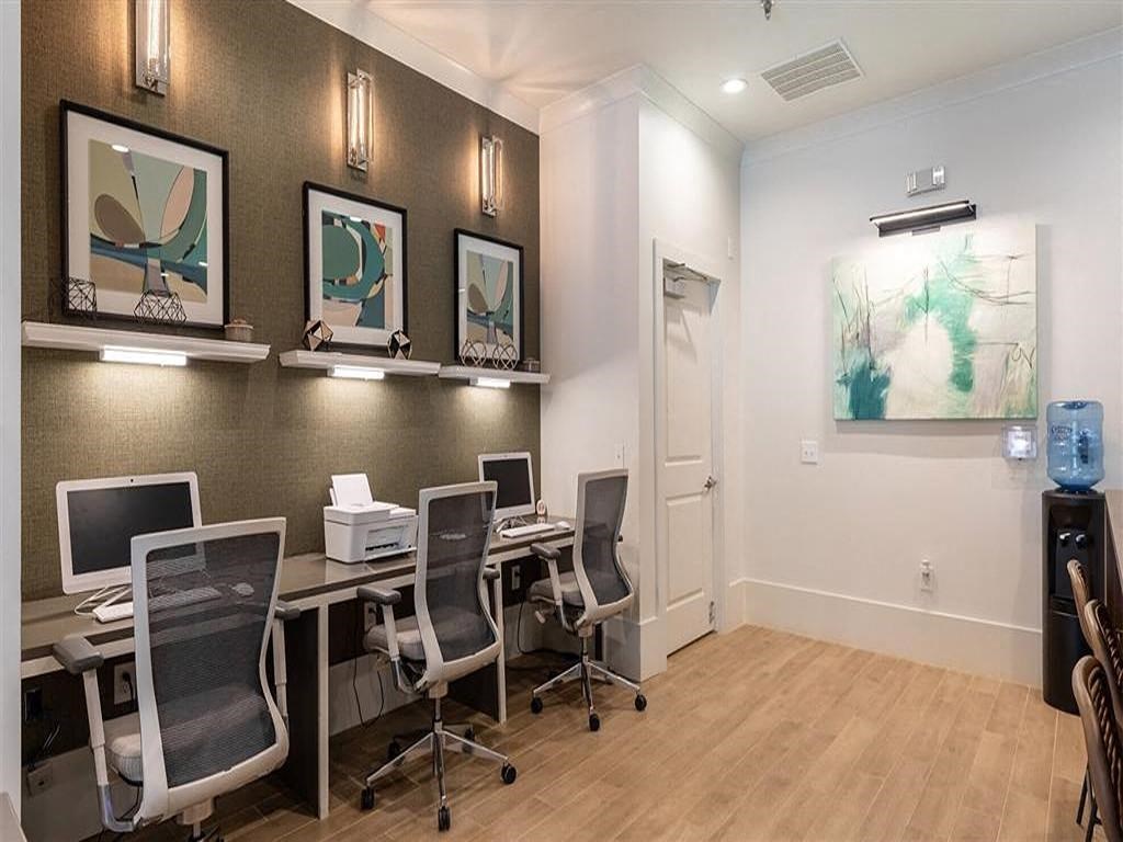 a conference room with desks and chairs and paintings on the wall