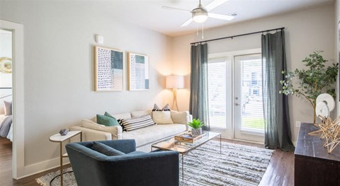 A living room with a blue chair and a white sofa.