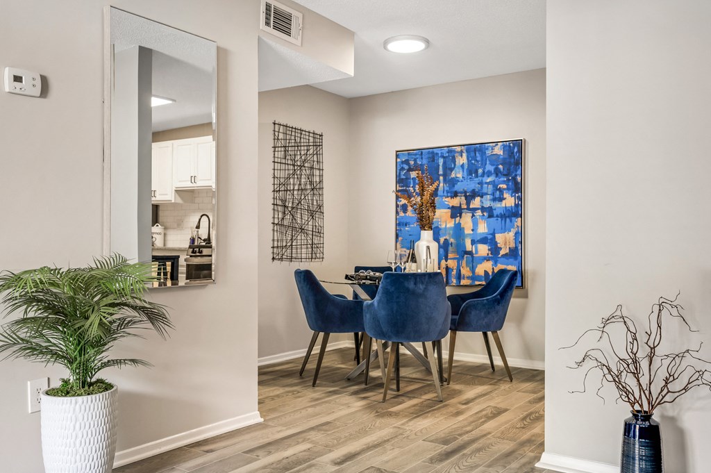 a dining room with a table and chairs and a painting on the wall