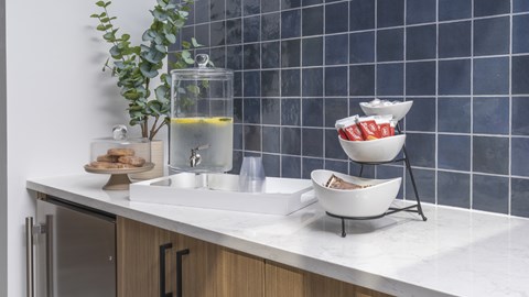 A kitchen counter with a bowl of cereal and a glass of water.