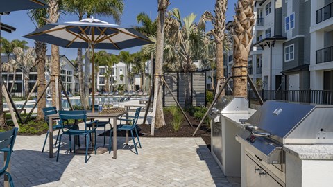 A patio with a table and chairs and an umbrella.