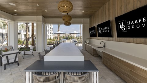 A dining area with a long table and chairs with a sign that says Harper Grove.