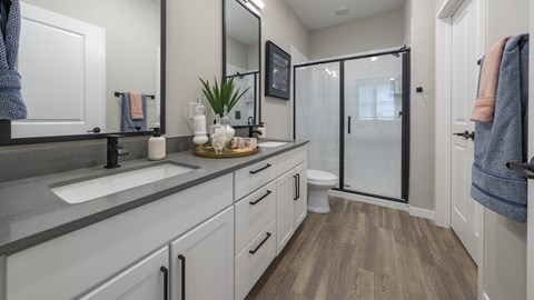 A bathroom with a sink, mirror, and a glass shower door.