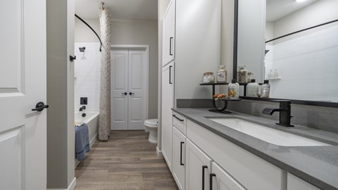 A bathroom with a white door and a white sink.