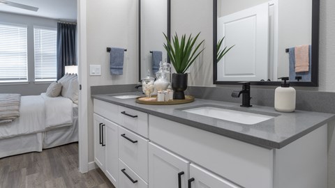 A bathroom with a white vanity and a mirror above it.
