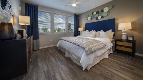A bedroom with a large bed and a wooden dresser.
