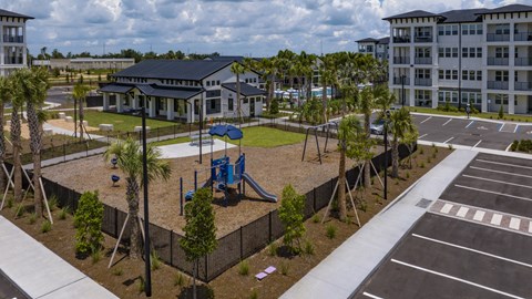 A playground with a slide and a building in the background.