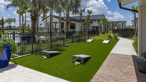 A modern backyard with a black fence and a brick walkway.