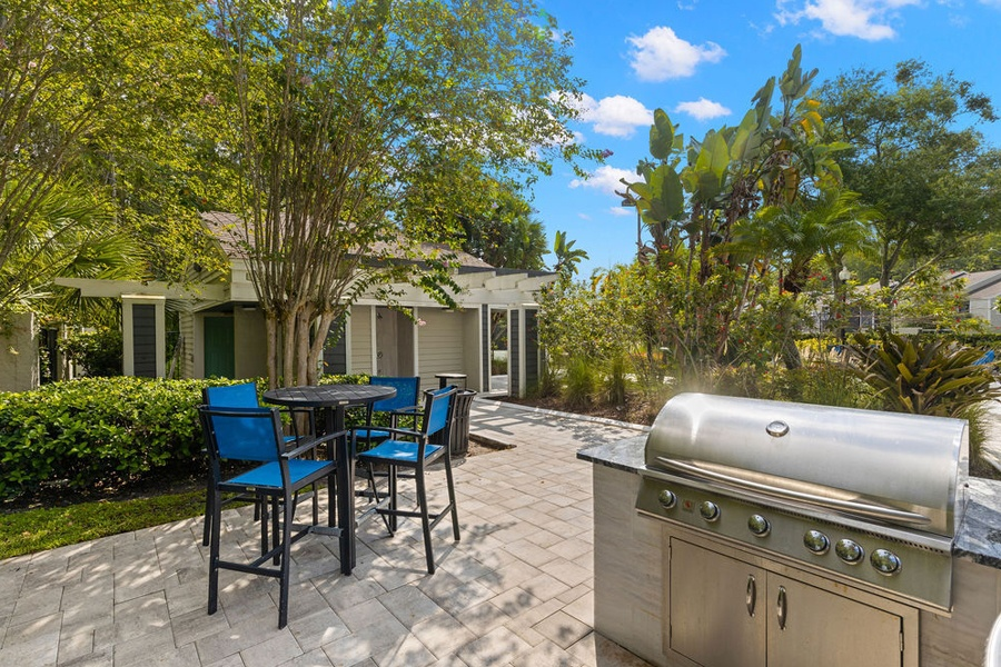 a backyard with a barbecue grill and a table and chairs