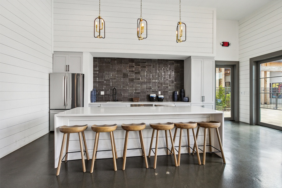 a kitchen with white walls and a white counter top and wooden stools