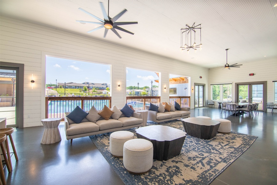 a large living room with couches and tables and a balcony