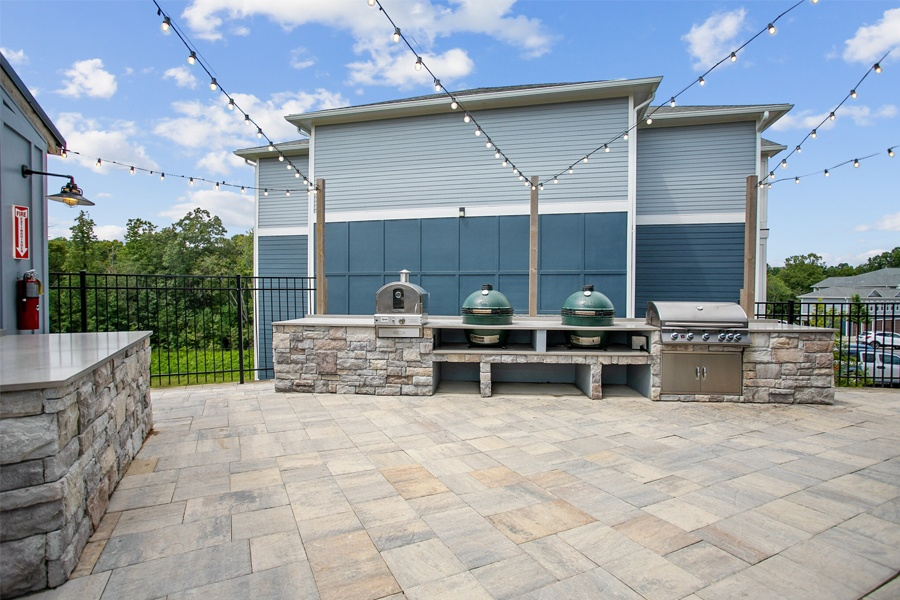 a large patio with a grill and a table with two pots on it