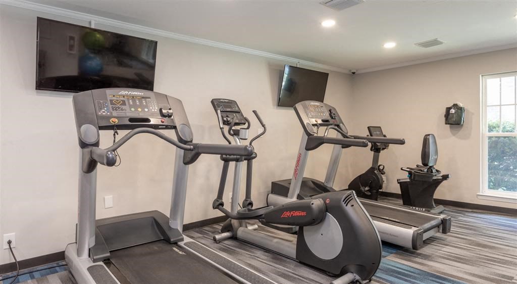 a gym with two machines and a tv on the wall