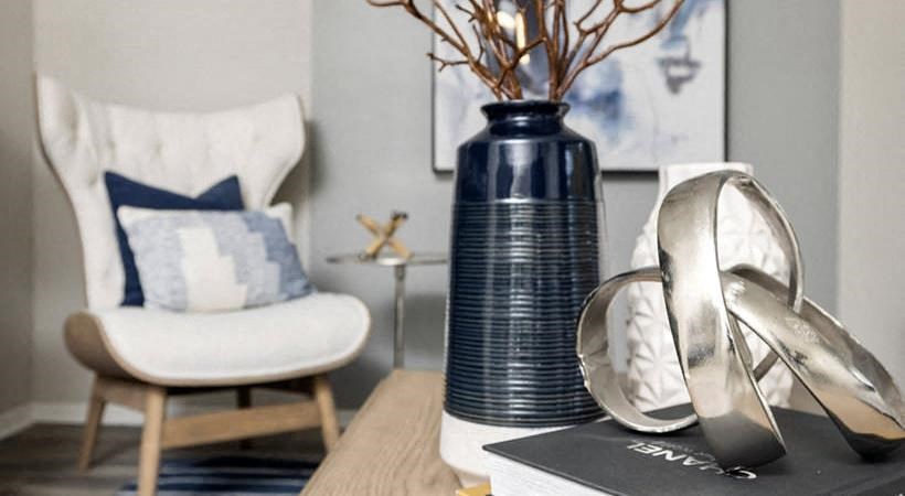 a table with shoes and a blue vase on it