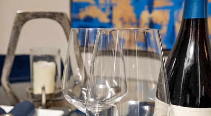 two wine glasses and a bottle on a table