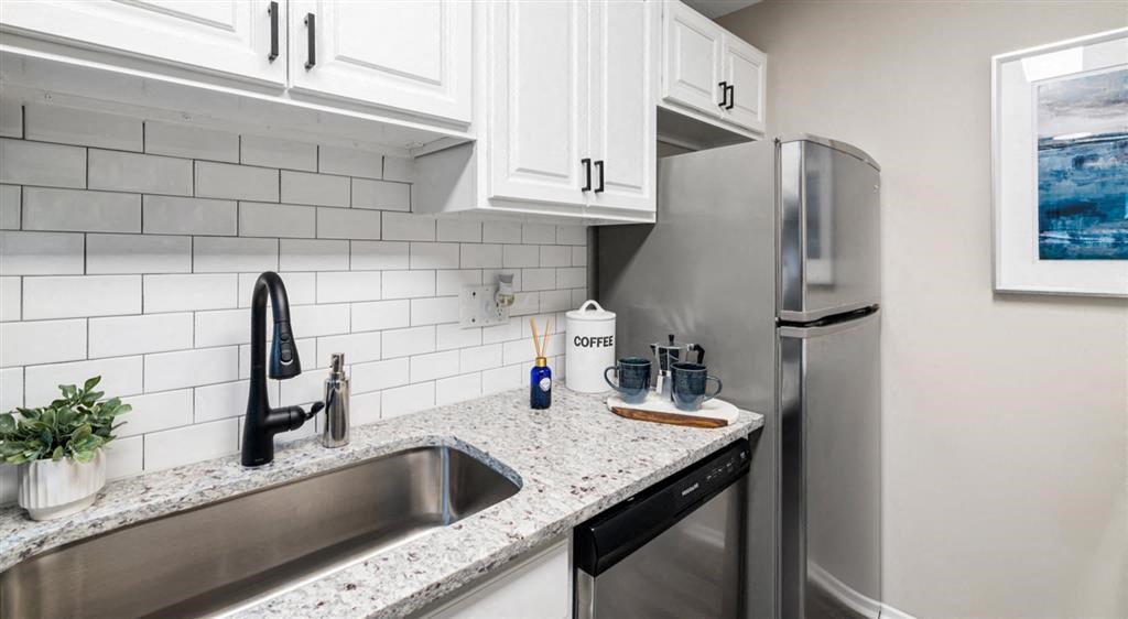 a kitchen with a sink and a stainless steel refrigerator