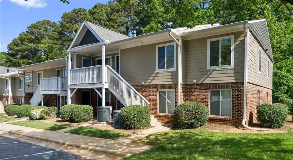 a tan house with a porch and a staircase