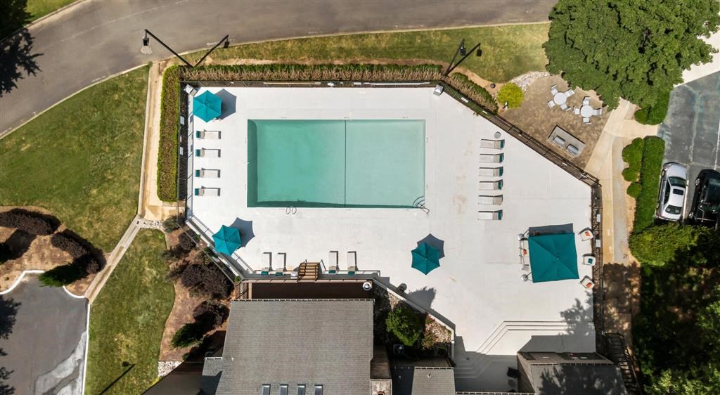 an aerial view of a building with a tennis court and umbrellas