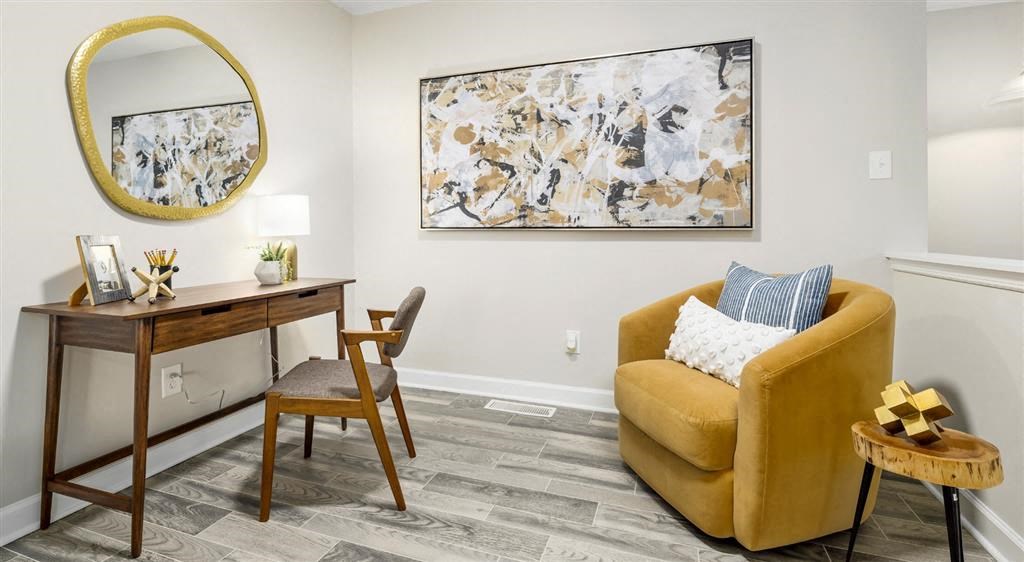 a living room with a yellow chair and a desk