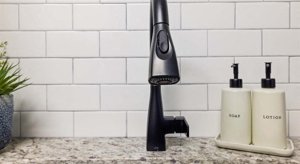 a kitchen sink with two bottles of soap and a tap