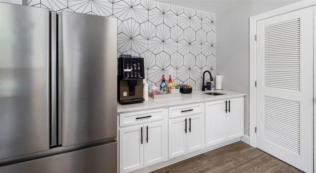 a kitchen with white cabinets and a stainless steel refrigerator